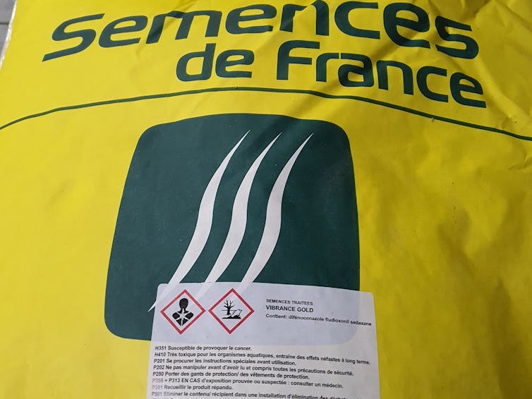 Avertissements sur un sac de semences traitées.